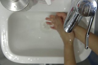 image of rinsing hands in the sink