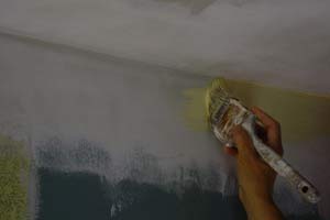 photo brushing wall paint along a ceiling corner