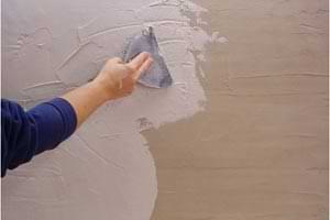 photo spreading white coat plaster over brown coat