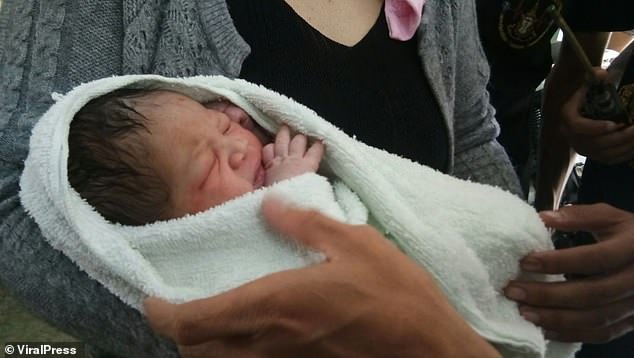 A newborn baby boy (pictured) has survived being thrown from a fifth floor balcony by his teenage mother - after banana leaves cushioned his fall