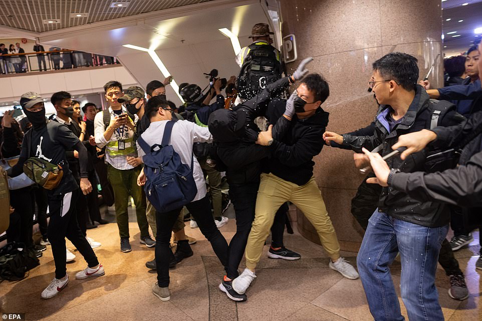 Plain clothed police officers clash with pro-democracy protesters in a shopping mall in Hong Kong on Christmas Eve