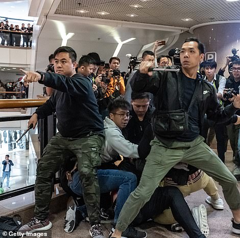 Officers dressed in plain clothes clash with the tide of Hong Kong protesters inside a shopping mall on the eve of Christmas
