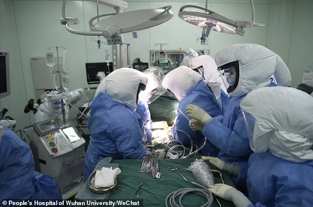 Medics are pictured wearing goggles, full-body protective suits and head shields during the double-lung transplant on April 20 at People