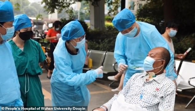 Mr Cui is the first COVID-19 sufferer in the province of Hubei to recover from the infection following a double-lung transplant. The handout shows doctors in Wuhan talking to Mr Cui