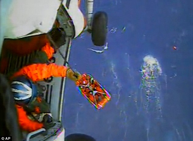 Life-saving: A coastguard crew member uses a hoist to bring up a survivor into a helicopter