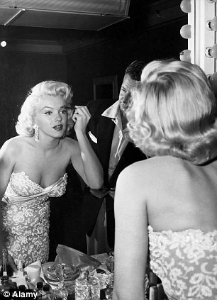 Showgirl: Marilyn Monroe applying make up at her mirror