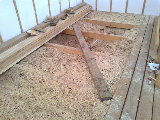Перед тем как начать утеплять потолок опилками, необходимо застелить картоном всю площадь потолочного перекрытия, а затем уже распределять состав и утрамбовывать