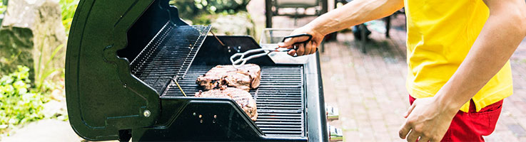 man cooking steaks on a grill