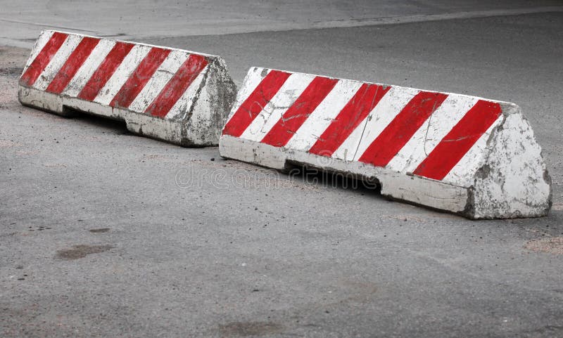 Red and white striped concrete road barriers royalty free stock photo