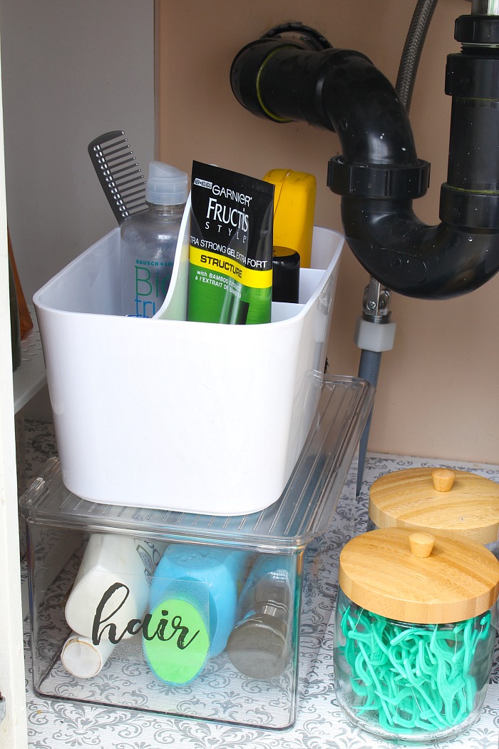 Bathroom caddy and labeled bathroom organization bins.