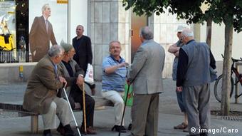A group of elderly men sit and stand near a bench, talking Copyright: imago/Caro Berlin, Deutschland -