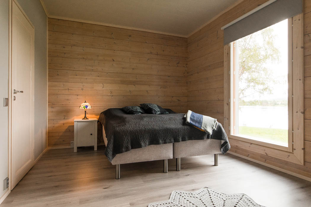 Master bedroom in a cosy wooden cottage by Rovaniemi Log House.